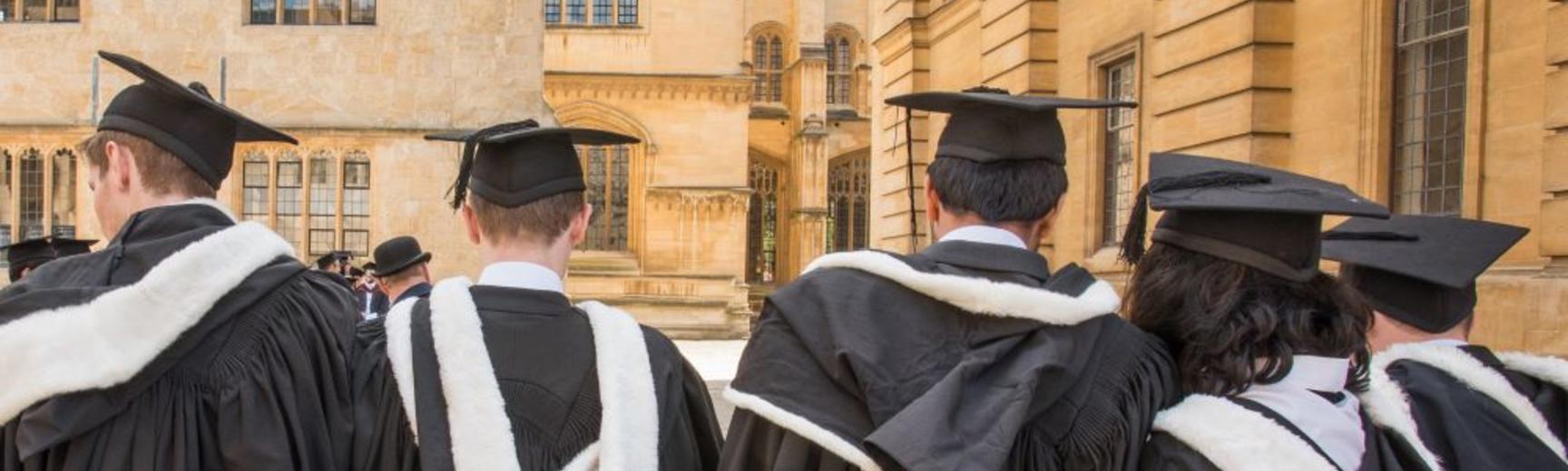 Students wearing gowns and mortar boards outside the Sheldonian