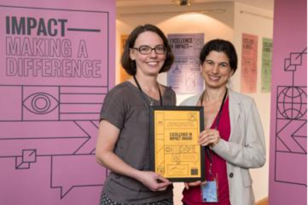 Professor Lucie Cluver and Joy Todd, Head of Health and Human Behaviour research at the ESRC, smile for the camera as they hold the project's prize certificate