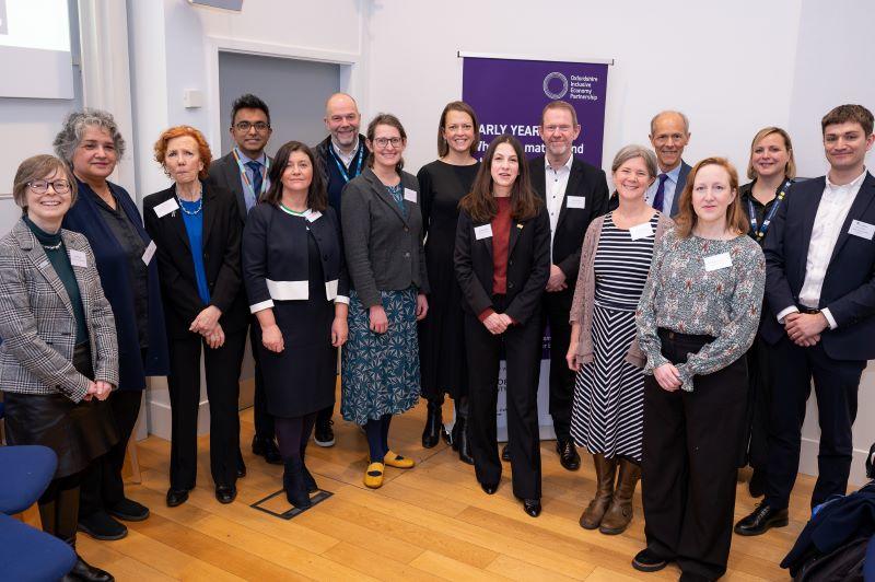 15 delegates from academia, policy, practice, business, and the third sector stand together