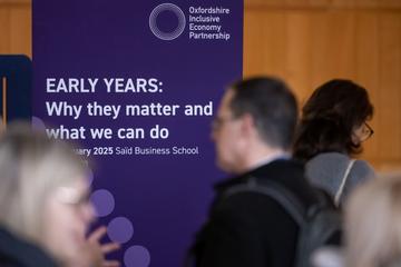 An event banner with the words "Early Years: Why they matter and what we can do" amongst a busy room of delegates