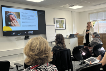 Dr Ruta presents a powerpoint to room of attendees 