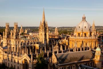An image of the Radcliffe Camera and All Soul's College taken from rooftop level. The buildings are lit up by golden hour sunlight, against a blue sky. ©OUImages /Whitaker studio