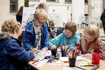 Festival of Social Science 2024 Four children participate in an activity using colouring pencils